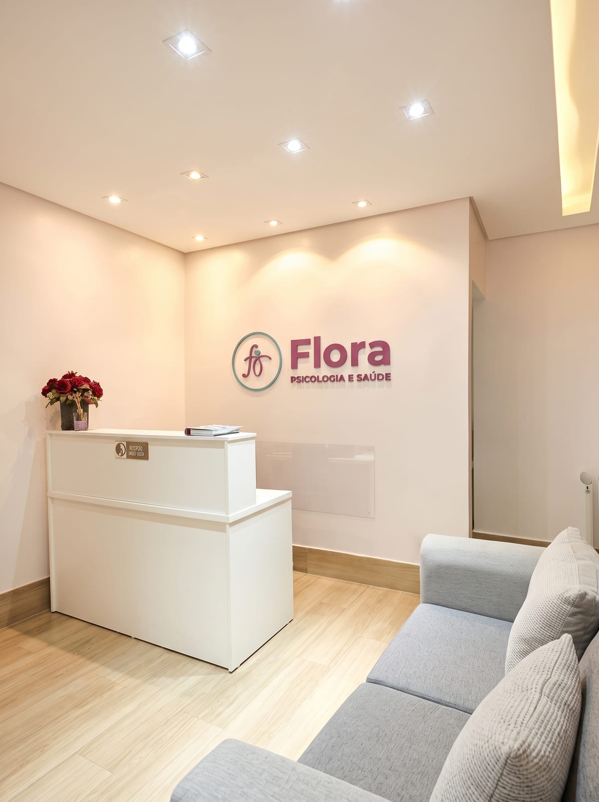 Recepção da Clínica Flora, com balcão de atendimento e sala de espera